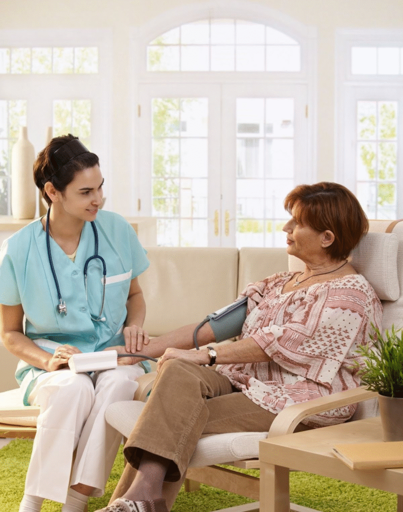 Nurse providing in-home care support to elderly woman in living room, promoting healthier living at home and personalised aged care services.