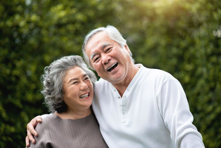Smiling senior couple embracing outdoors, representing ageing at home challenges and solutions, independence, and happy senior living.
